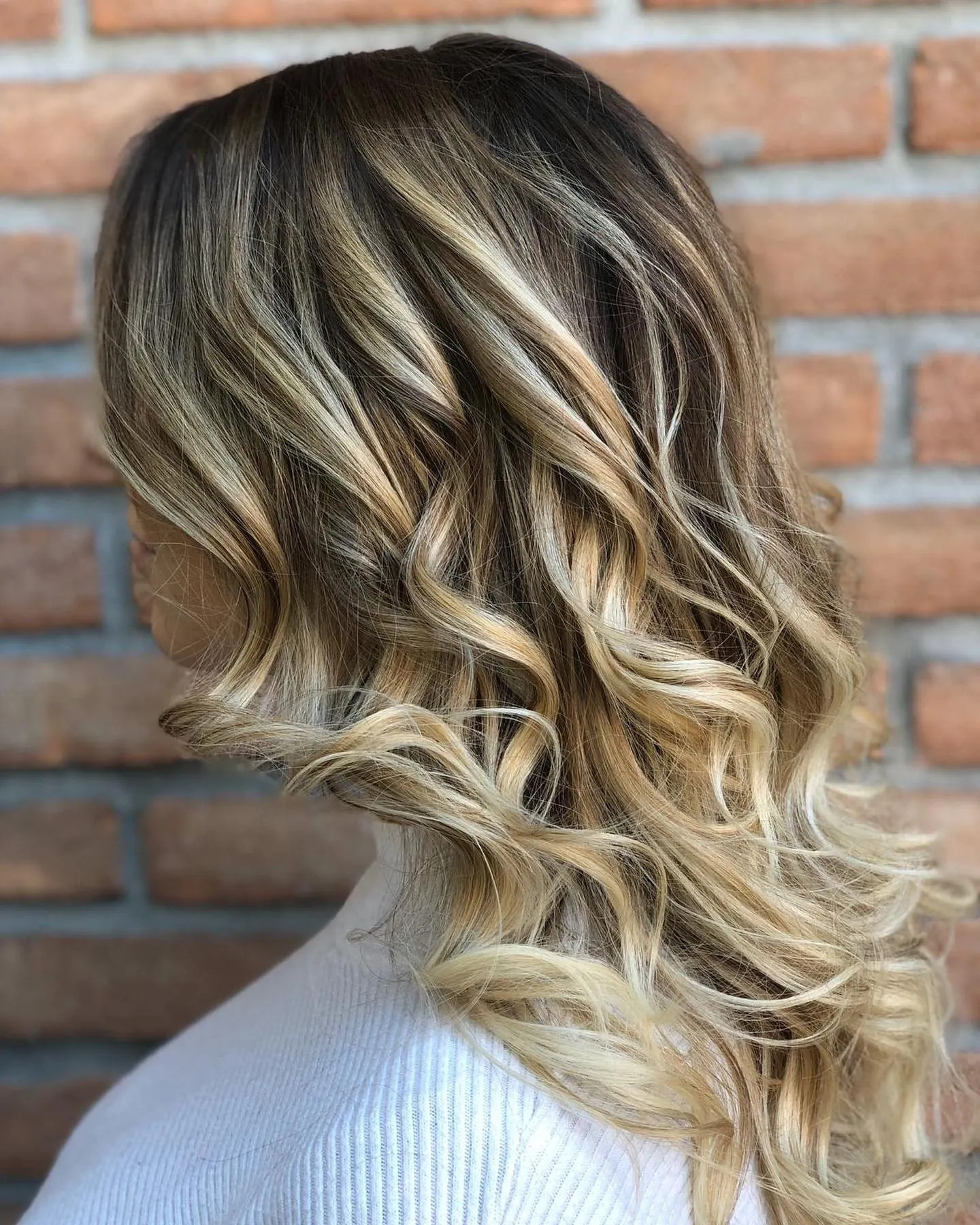 Balayage biondo su capelli lunghi mossi