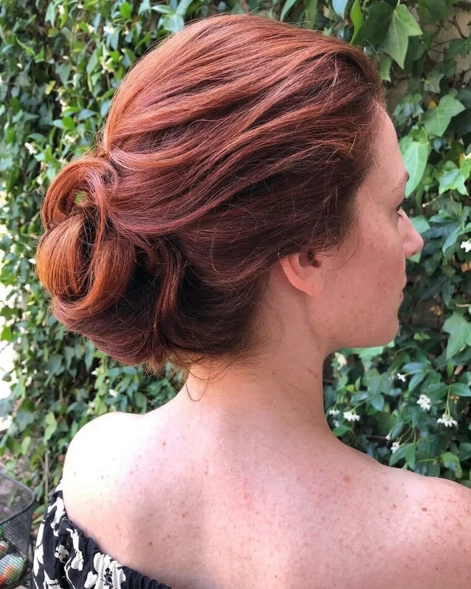 Chignon basso morbido su capelli ramati