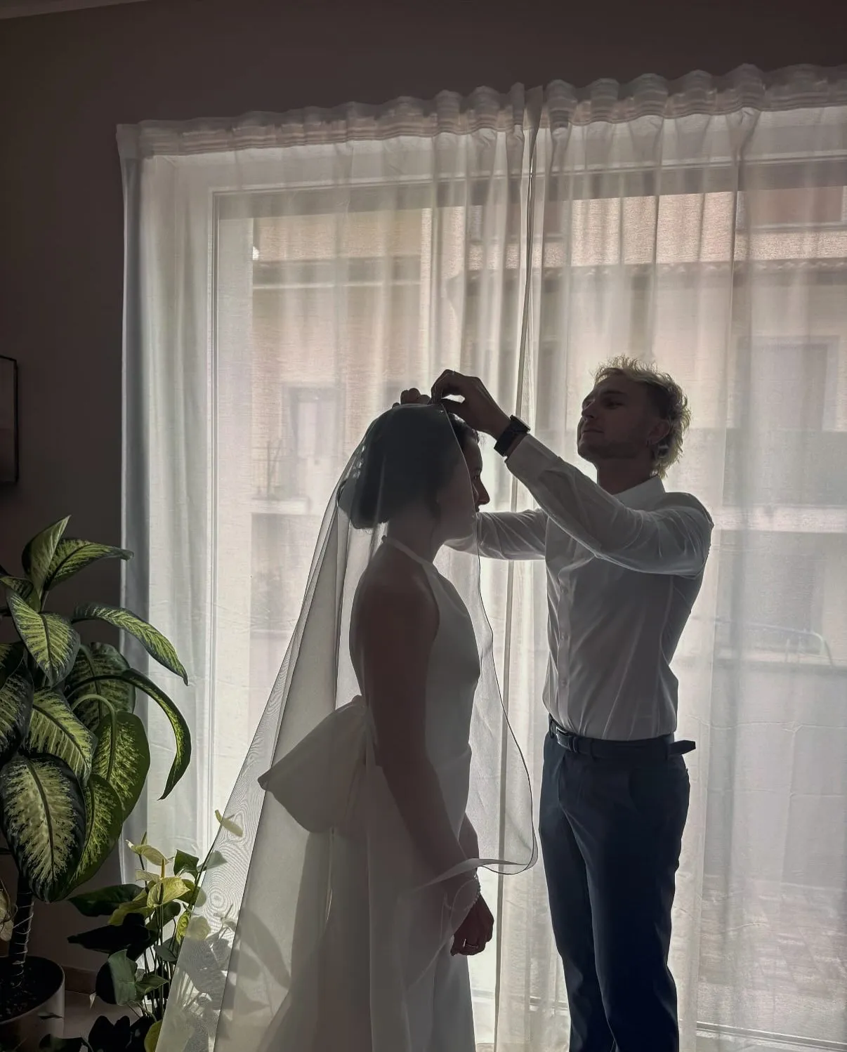 Il parrucchiere sistema il velo sull'acconciatura della sposa