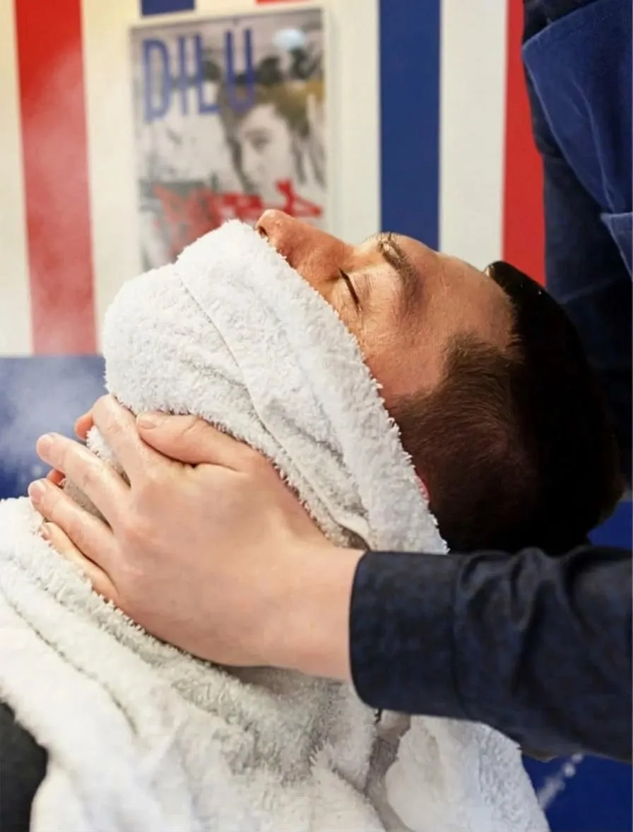 Panno caldo sul viso per preparare la barba